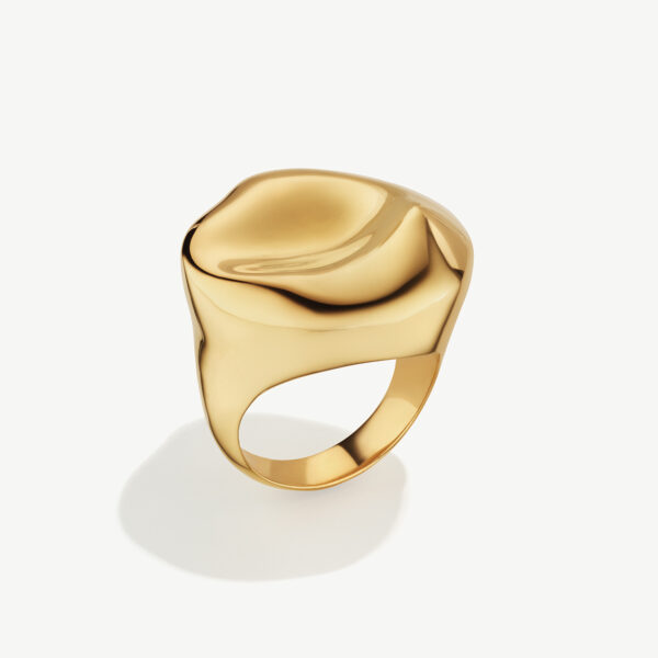 An abstractly shaped gold ring with the bulk of the ring being at the top.