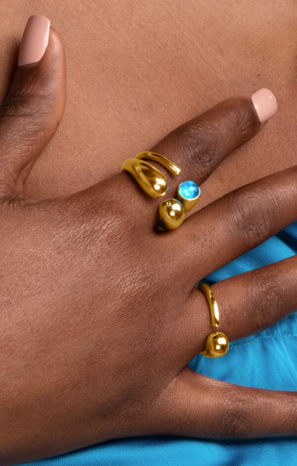 A person's hand with various gold rings on it.