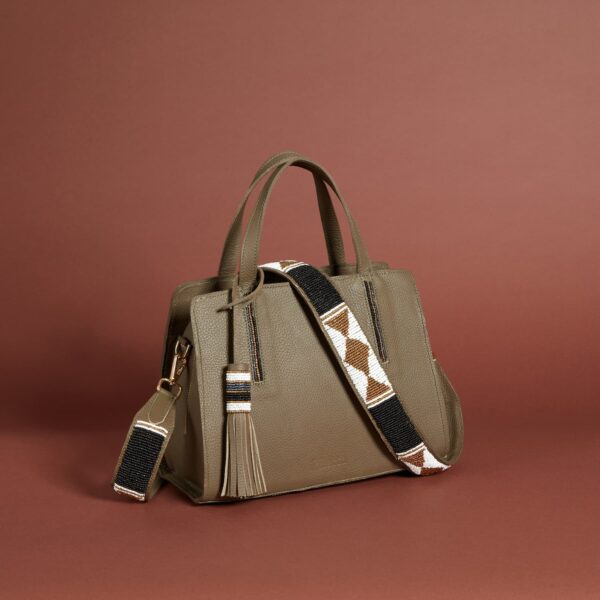 A pale olive/khaki colored bag with a brown, white, and black beaded strap and tassel.