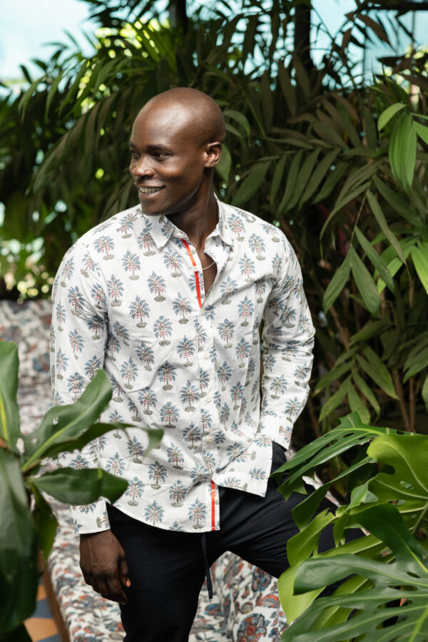 A man wearing a white button up shirt with a graphic pattern