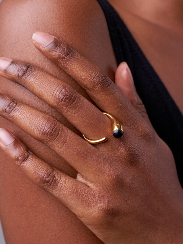person wearing 24K gold-plated recycled brass ring with recycled horn in black
