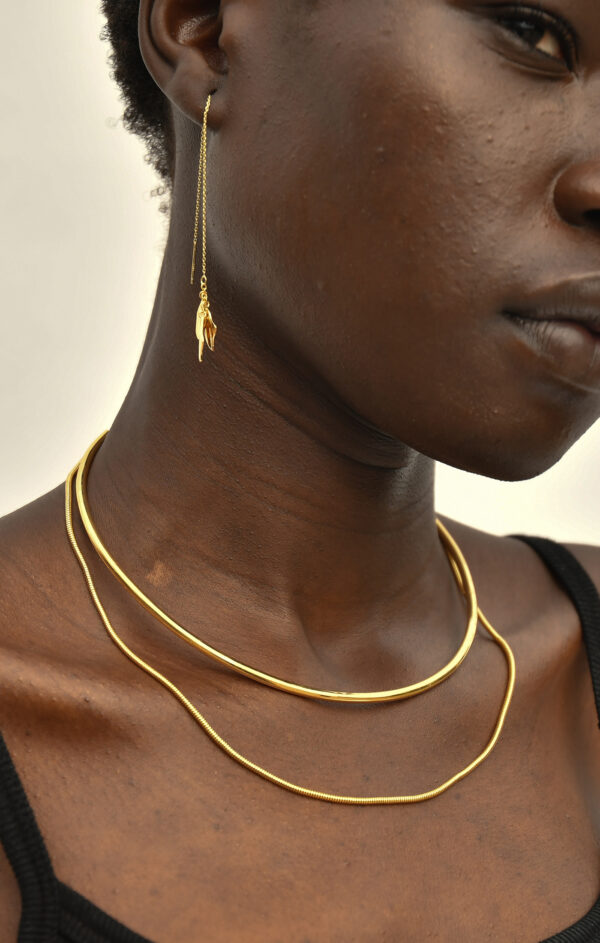 person wearing gold necklace