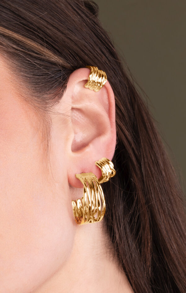 person wearing gold hoop earrings