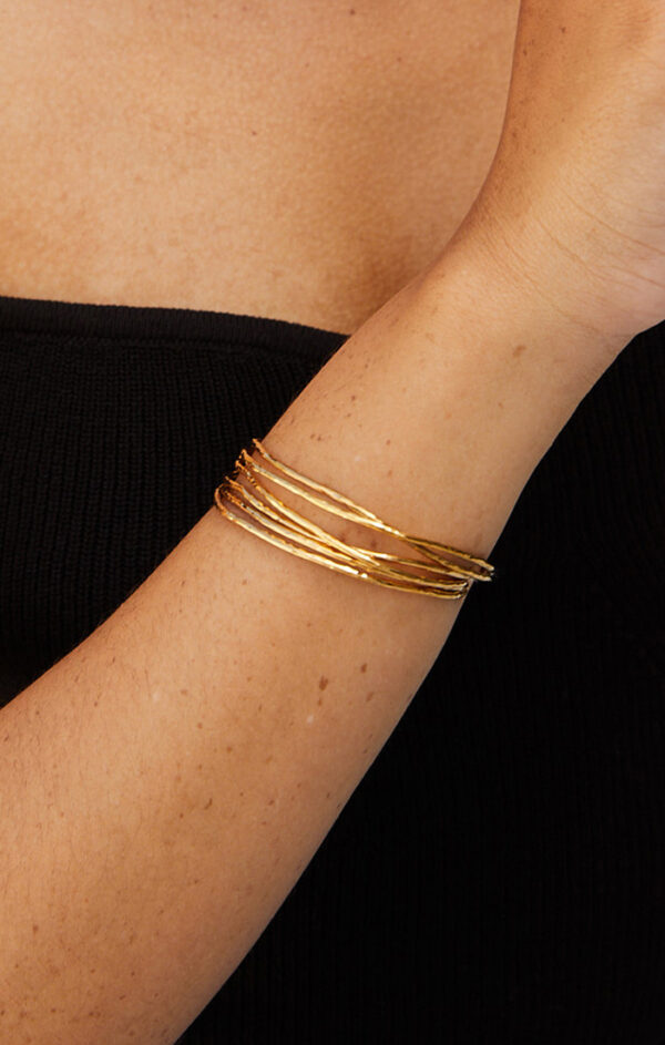 person wearing gold stacking bracelets